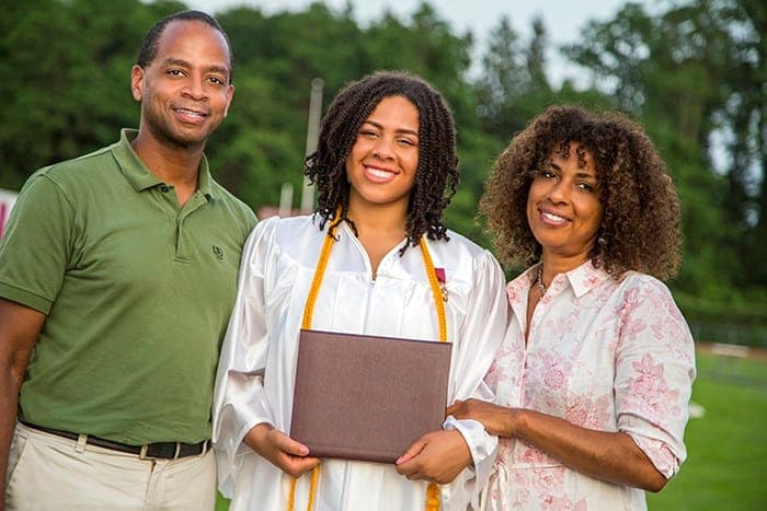 Teenage girl with parents at graduation